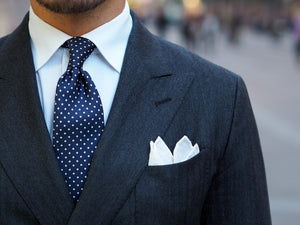 Blue pin dot tie with a gray double-breasted suit